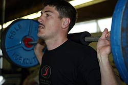 Andrew completing squats at a weights training session